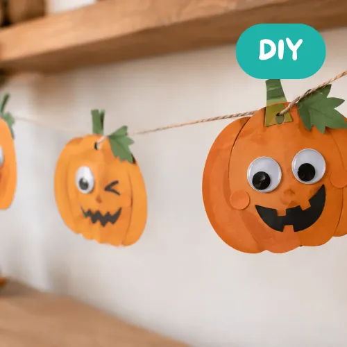 Halloween-Kürbis-Girlande aus orangefarbenem Papier mit einem Kürbis mit großen Wackelaugen DIY